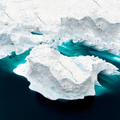 A floating glacier in blue water.